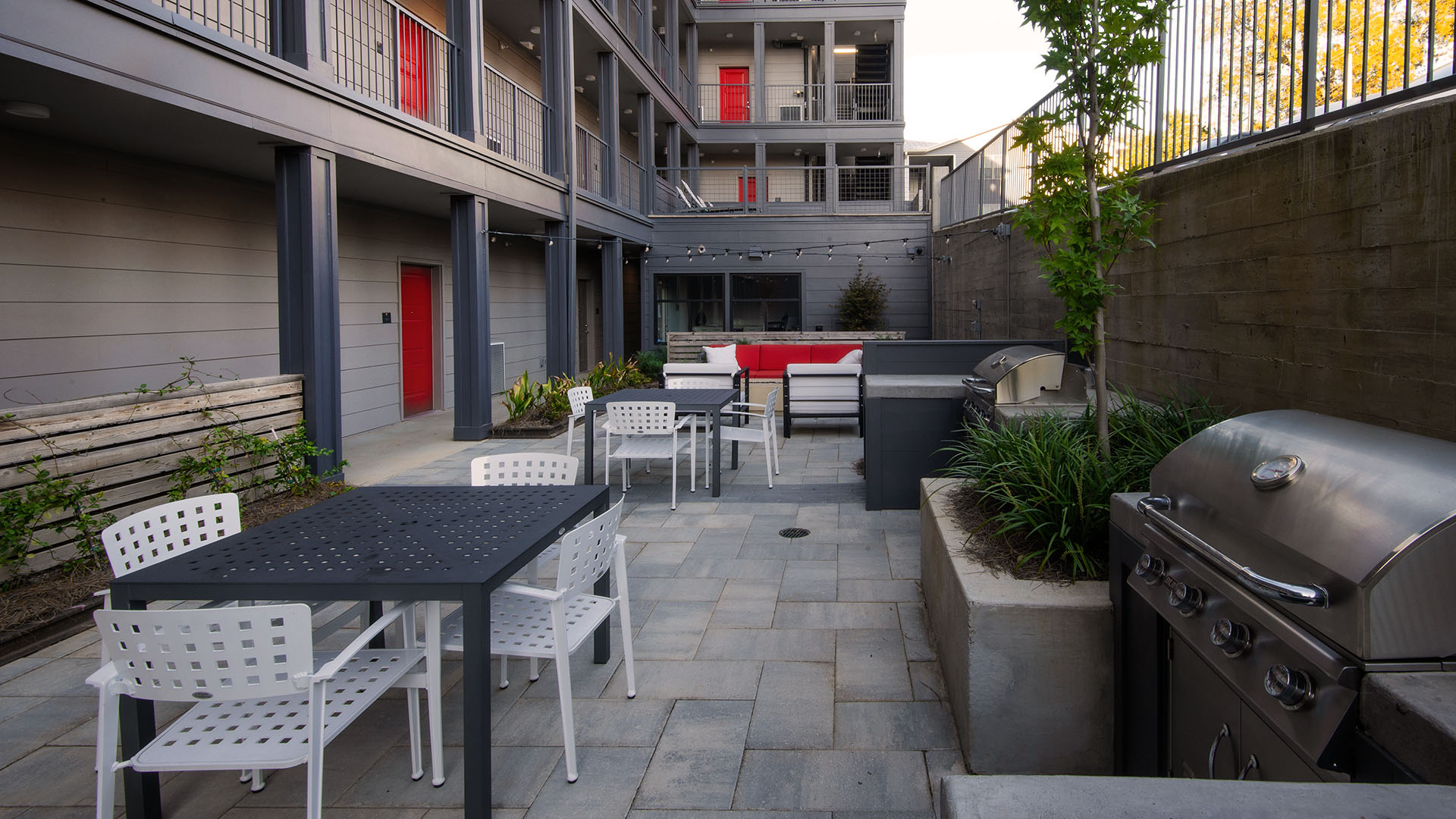 outdoor gas grills, cushioned outdoor furniture adjacent to nearby walking spaces
